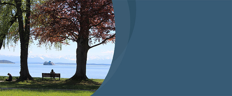 Starnberger See mit Schiff und einer Person auf der Bank