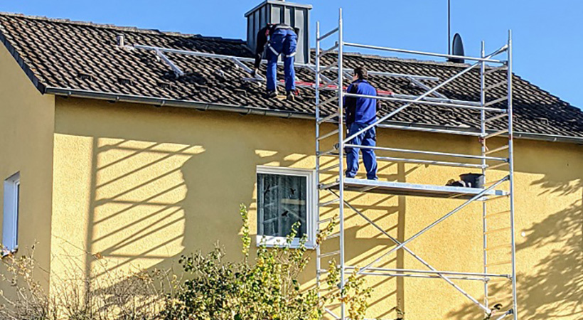 Zwei Mitarbeiter bei einer Installation auf dem Dach.