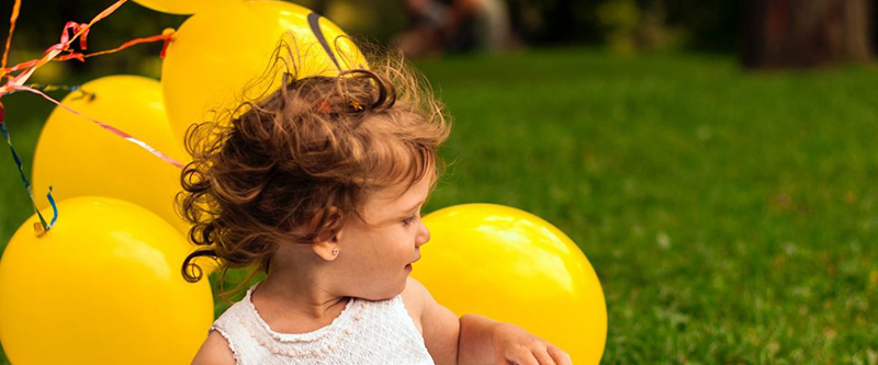 Baby mit gelben Luftballons