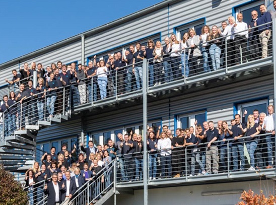 Gruppen von Mitarbeitern auf den Gehwegen des Gebäudes