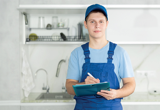 Handwerker macht Notizen in der Küche