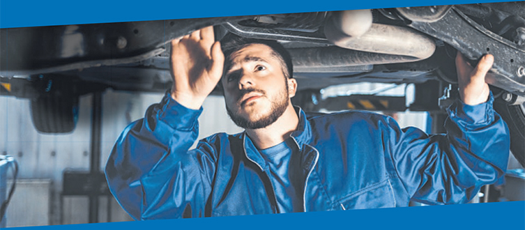 Automechaniker inspiziert Autofahrwerk
