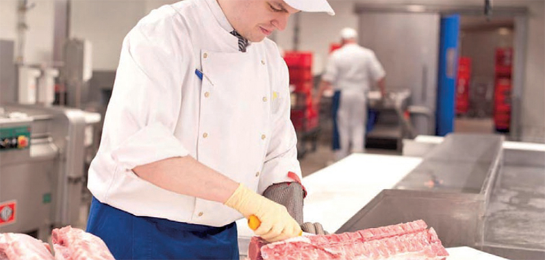 Metzger schneidet Fleisch in der Metzgerei