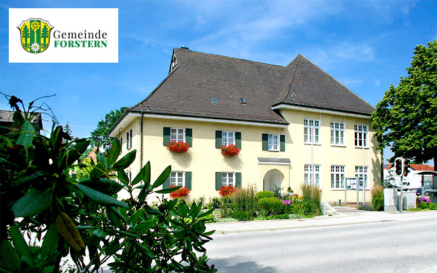 Ein gelbes Gebäude mit Fenstern und Blumen.
