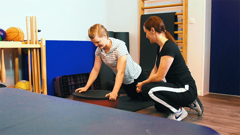 Patientin macht Übungen unter Anleitung einer Therapeutin