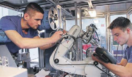 Mitarbeiter arbeiten an einem Robotermechanismus.