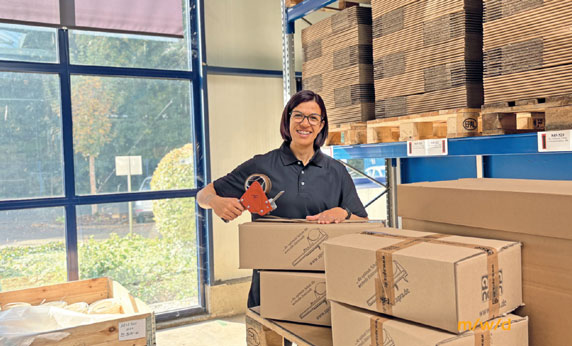 eine Mitarbeiterin verpackt die Waren