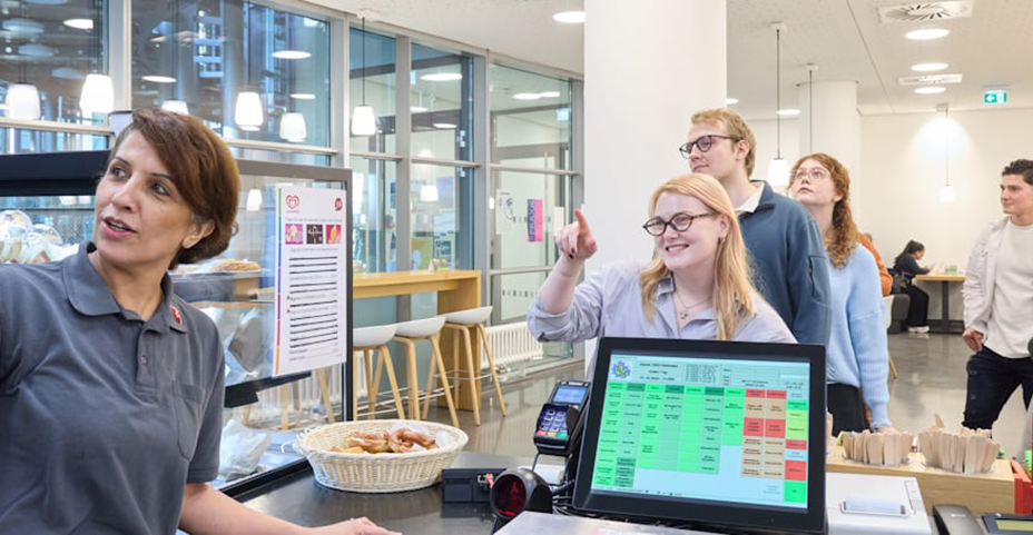 Kassiererin bedient Gäste in einer modernen Kantine
