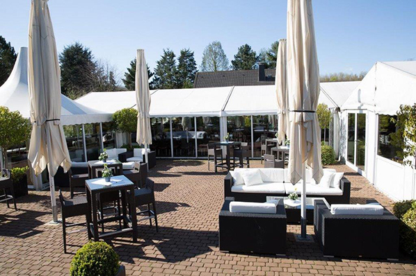 Elegante Außenterrasse mit Lounge-Möbeln und weißen Sonnenschirmen