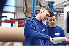 Arbeiter prüfen Maschine gemeinsam