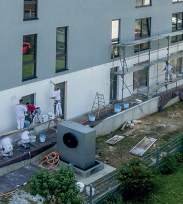 Maler arbeiten an einer hellen Hausfassade