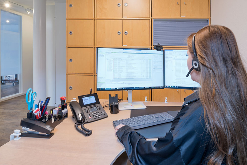 Frau mit Headset am PC