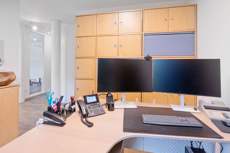 Schreibtisch vor Holzschrankwand