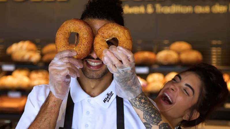 Ein Mann hält sich zwei Bagels vor die Augen