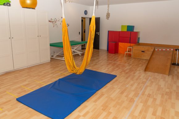 Orangefarbenem Schlingentrainer und ein blauer Teppich unten