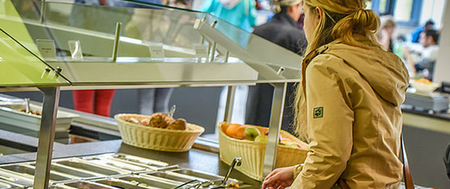 Studentin stellt sich Essen in Mensa zusammen