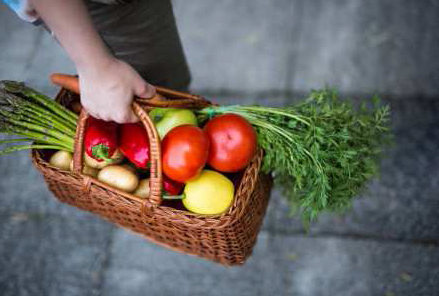 Korb mit frischem Gemüse und Obst mit Tomaten, Karotten und Kartoffeln