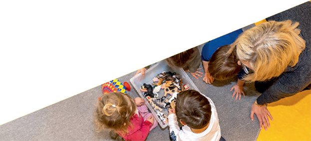 Eine Frau und Kinder spielen mit Spielzeug