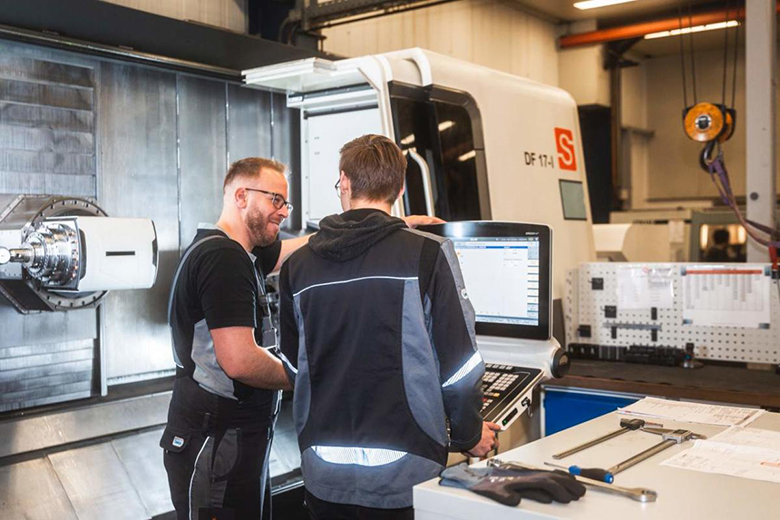 Zwei Männer an einer CNC-Steuerung