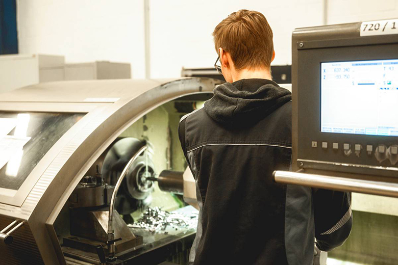 Ein Mann an einer CNC-Drehmaschine