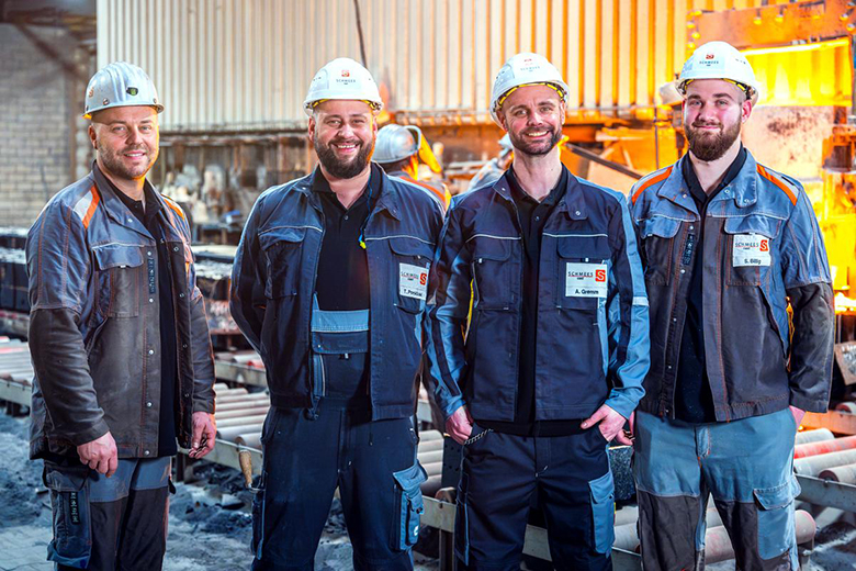 Vier Arbeiter in einer Gießerei