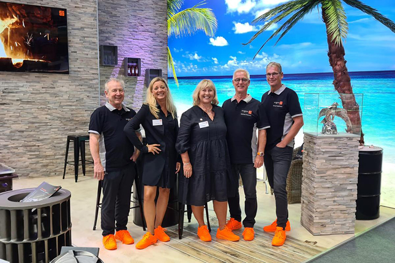 Fünf Personen mit orangefarbenen Schuhen auf einer Messe