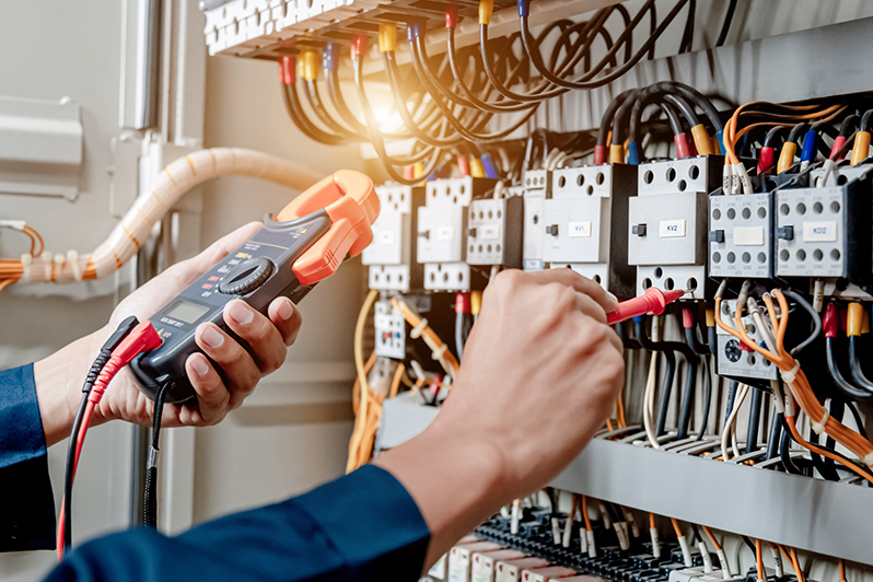 Eine Hand überprüft eine elektrische Schaltung