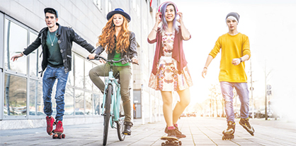 Vier Freunde fahren draußen Rollschuh, Fahrrad und Skateboard