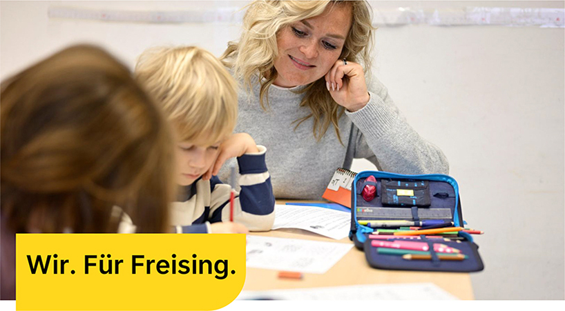 Wir. Für Freising. Mitarbeiter arbeiten an einer großen Maschine.