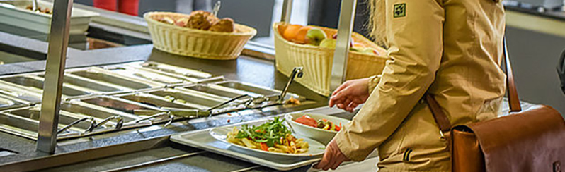 Eine Frau trägt ein Tablett mit Essen