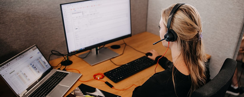 Eine Mitarbeiterin, die vor einem Computerbildschirm arbeitet.