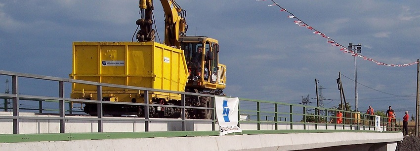 Bager mit Container auf der Brücke.