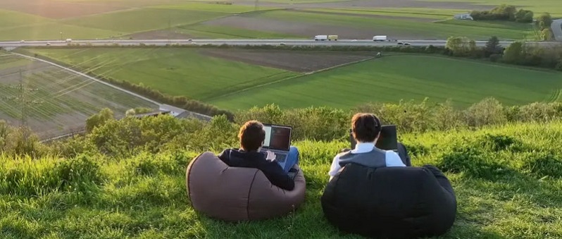 zwei Mitarbeiter bei der Arbeit in der Wildnis auf einem Hügel