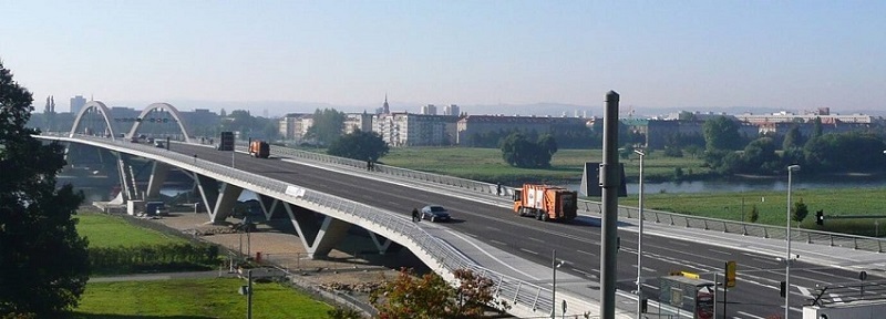 Fertiggestellte Brücke mit Fahrzeugen im alltäglichen Verkehr.