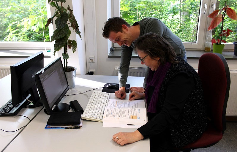 Sozialpädagoge hilft Frau, am Computer zu arbeiten