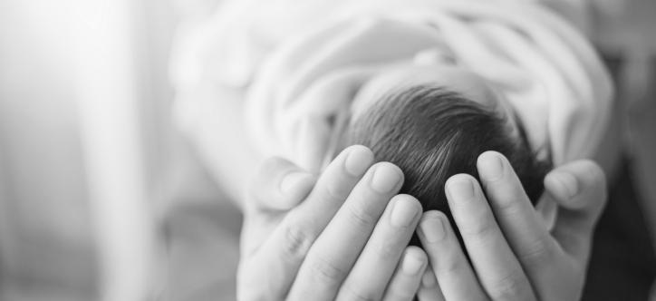 Kopf des Babys in den Händen