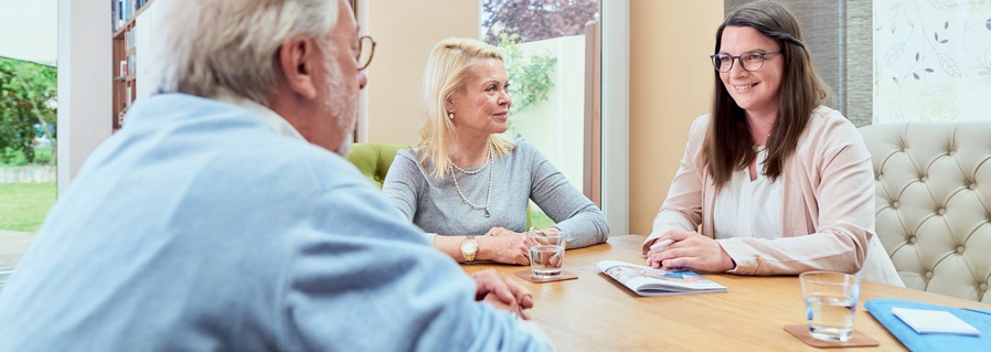 Pflegeberaterin im Gespräch mit zwei Patienten