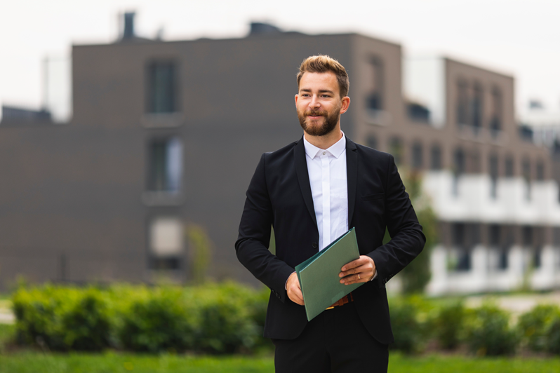 Junger Immobilienmakler im Anzug