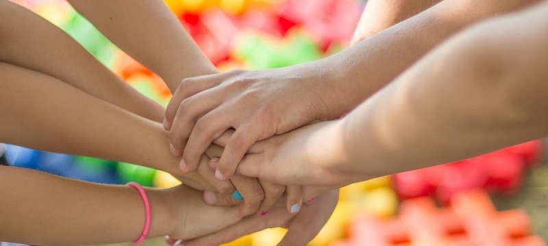 Kinder reichen sich zum Spielen die Hände