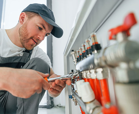 Installateur arbeitet mit Rohrzange.