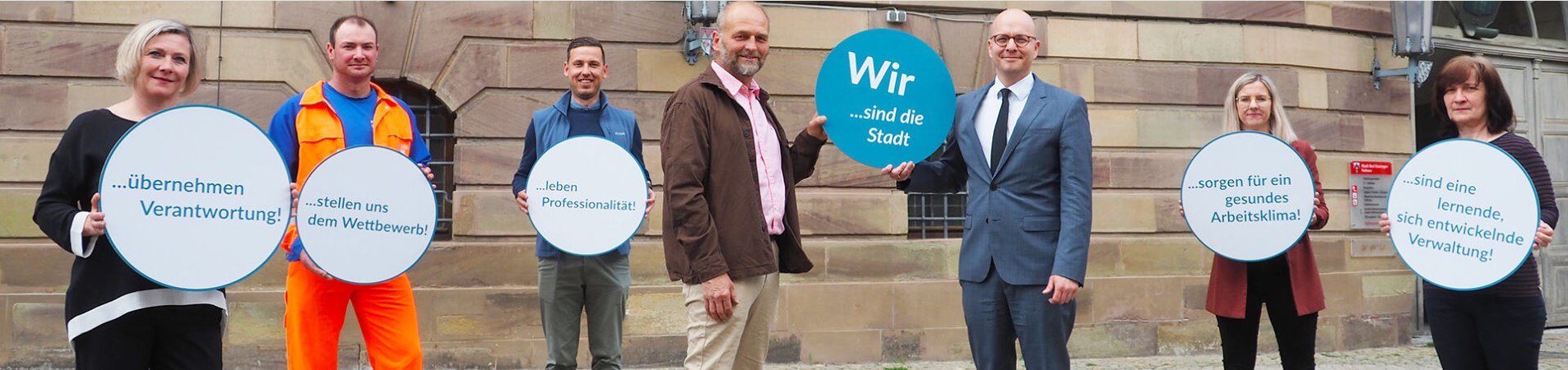Menschen mit Schildern vor Gebäude
