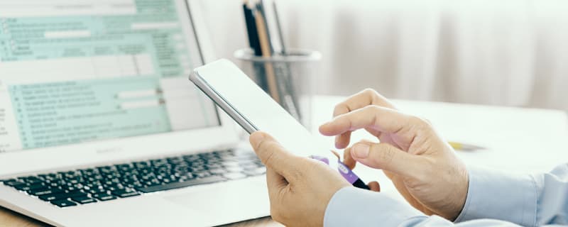 Die Person im Büro mit dem Telefon in der Hand