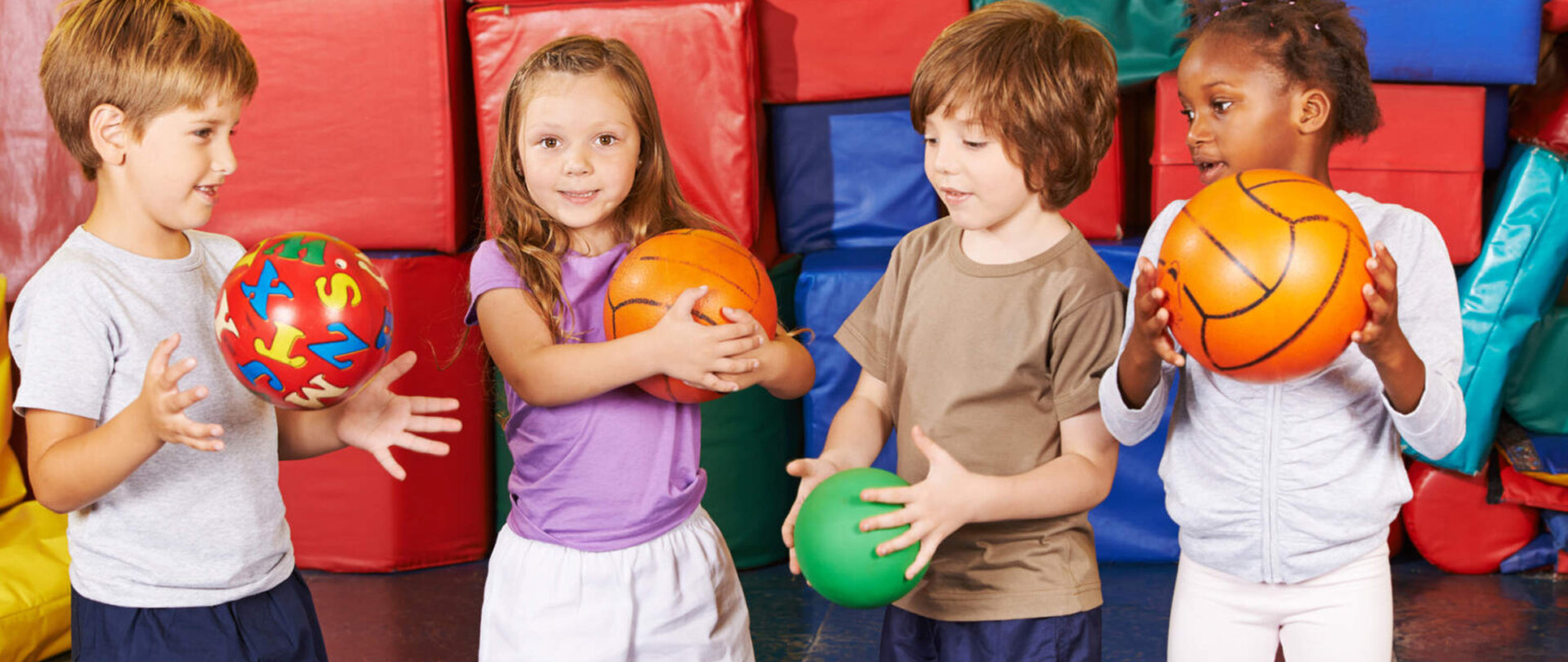 Kinder spielen mit Bällen drinnen