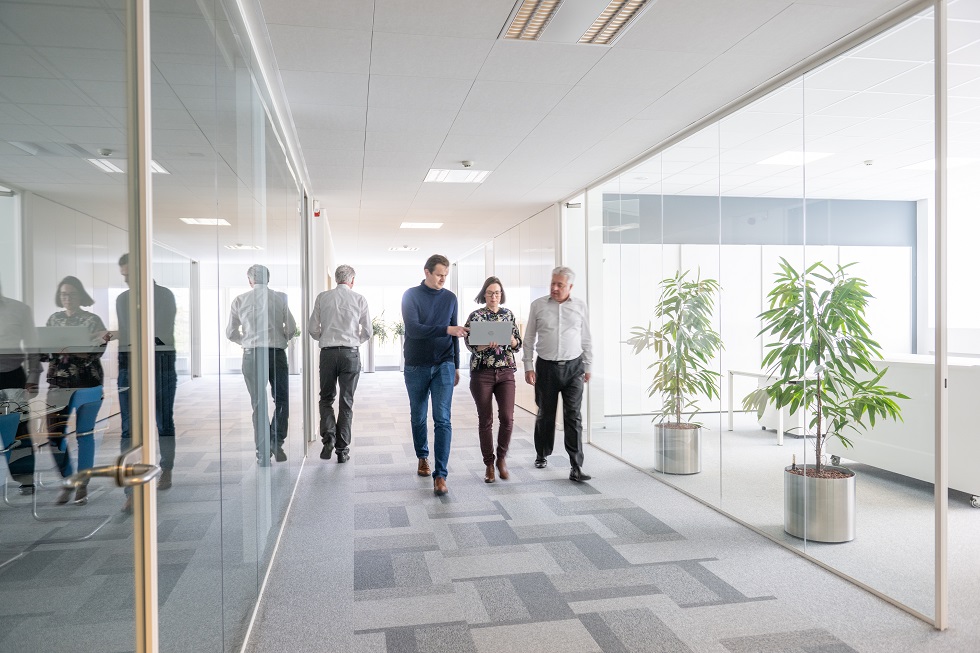 Menschen gehen durch Büroflur.