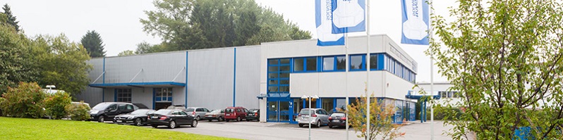 Parkplatz mit dem Firmengebäude davor