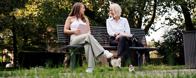 zwei Frauen im Gespräch auf einer Bank