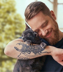 Mann spielt mit einer Katze