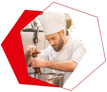 Koch würzt Essen in Küche