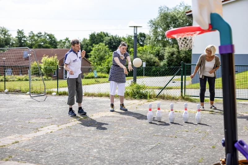 Zwei Frauen und ein Mann spielen mit einem Ball - DRK-Landesverband Schleswig-Holstein e. V. DRK Standort Raisdorf