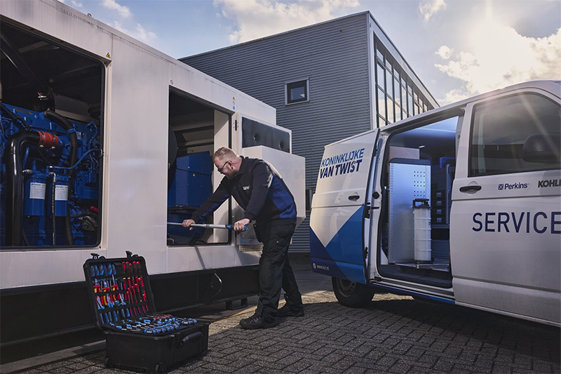 Servicetechniker neben dem Firmenwagen